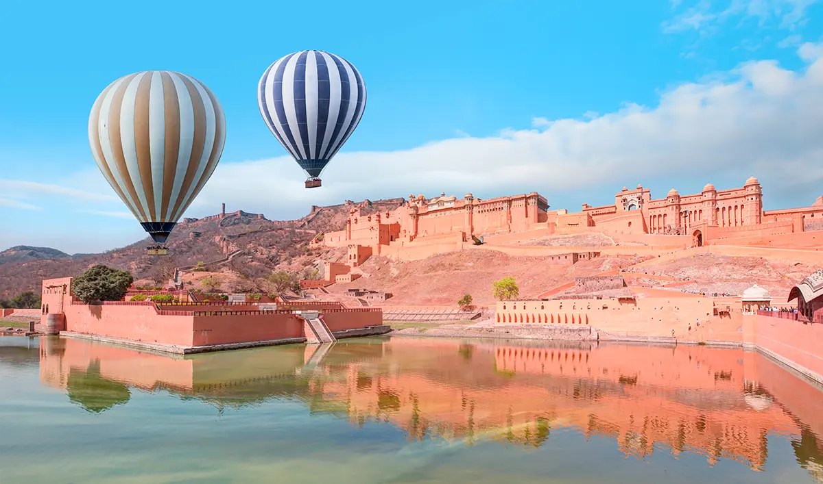 Aerial view of Amber Fort in Rajasthan with hot air balloons floating in the sky